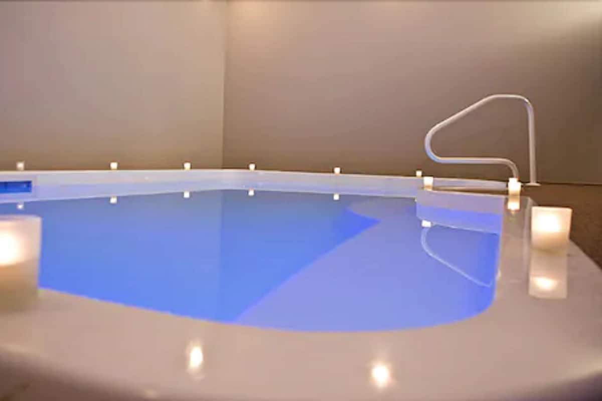 Ein moderner, überdachter Swimmingpool mit klar blauem Wasser, weißem Rand und schlichtem, klaren Design.