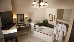 Une salle de bain d’hôtel avec une cheminée, une baignoire, un lavabo et un miroir.