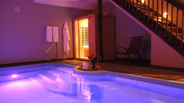 Une piscine avec une terrasse en bois et un escalier.