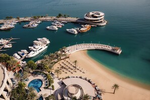 A marina with boats, a beach, and a pool area. - Four Seasons Hotel Doha (Doha)