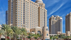 A large hotel with multiple floors, a central tower, and a beachside location. - Four Seasons Hotel Doha (Doha)