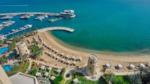 A coastal resort with a beach, a marina, and a tower. - Four Seasons Hotel Doha (Doha)