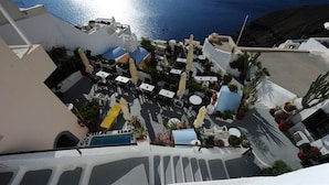 Una terraza en la azotea con mobiliario exterior, piscina y vistas al mar.