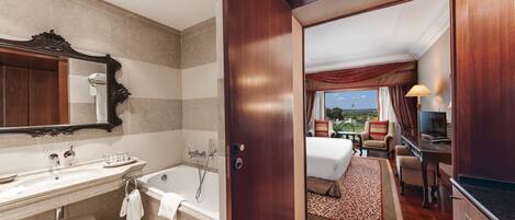 A bathroom with a bathtub, vanity, and a large mirror.