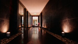 A long, dimly lit hallway with a polished floor, leading to a bright room at the end. - Convento do Espinheiro, Historic Hotel & Spa (Évora)