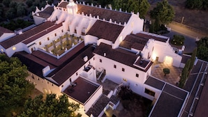 An aerial view of a white building with multiple roofs and a courtyard. - Convento do Espinheiro, Historic Hotel & Spa (Évora)