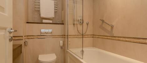 A bathroom with a glass-enclosed shower, a white toilet, and a bathtub.