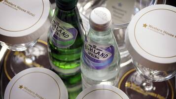 A tray with various items including bottles of Highland Spring water and containers labeled "Western House Hotel".