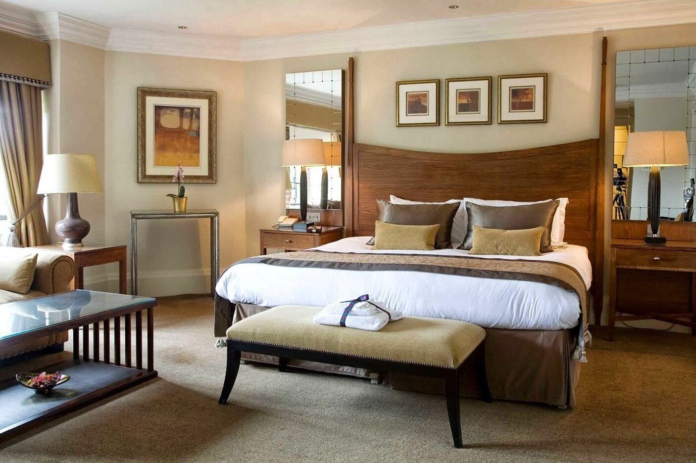 Una habitación de hotel con una cama grande, una mesita de noche, un escritorio y una silla.