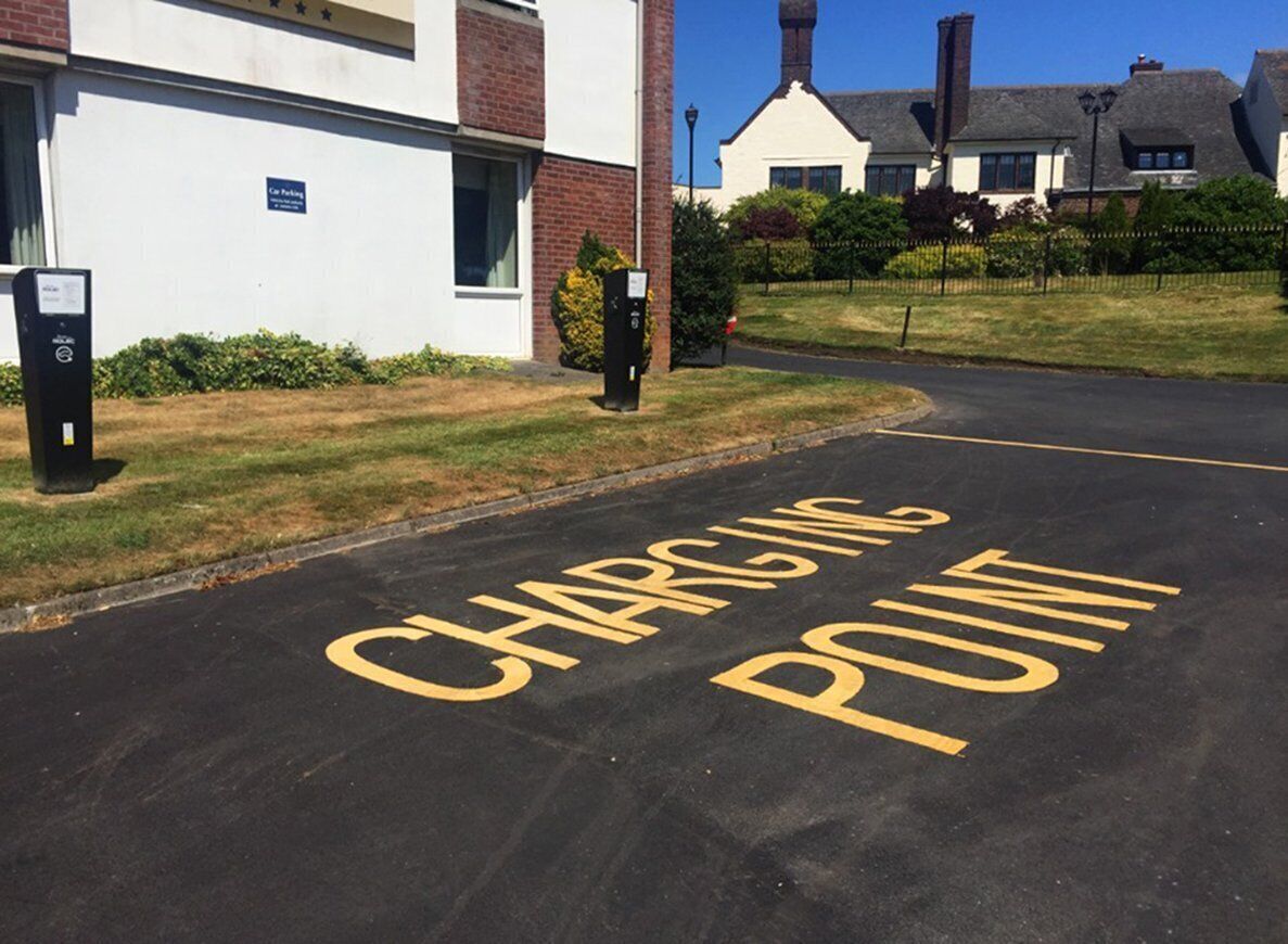 Un área de estacionamiento con un letrero que dice 'CHARGING POINT'.