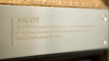 A plaque with the inscription "ASCOT" and a description about a famous race event attended by the Royal Family.