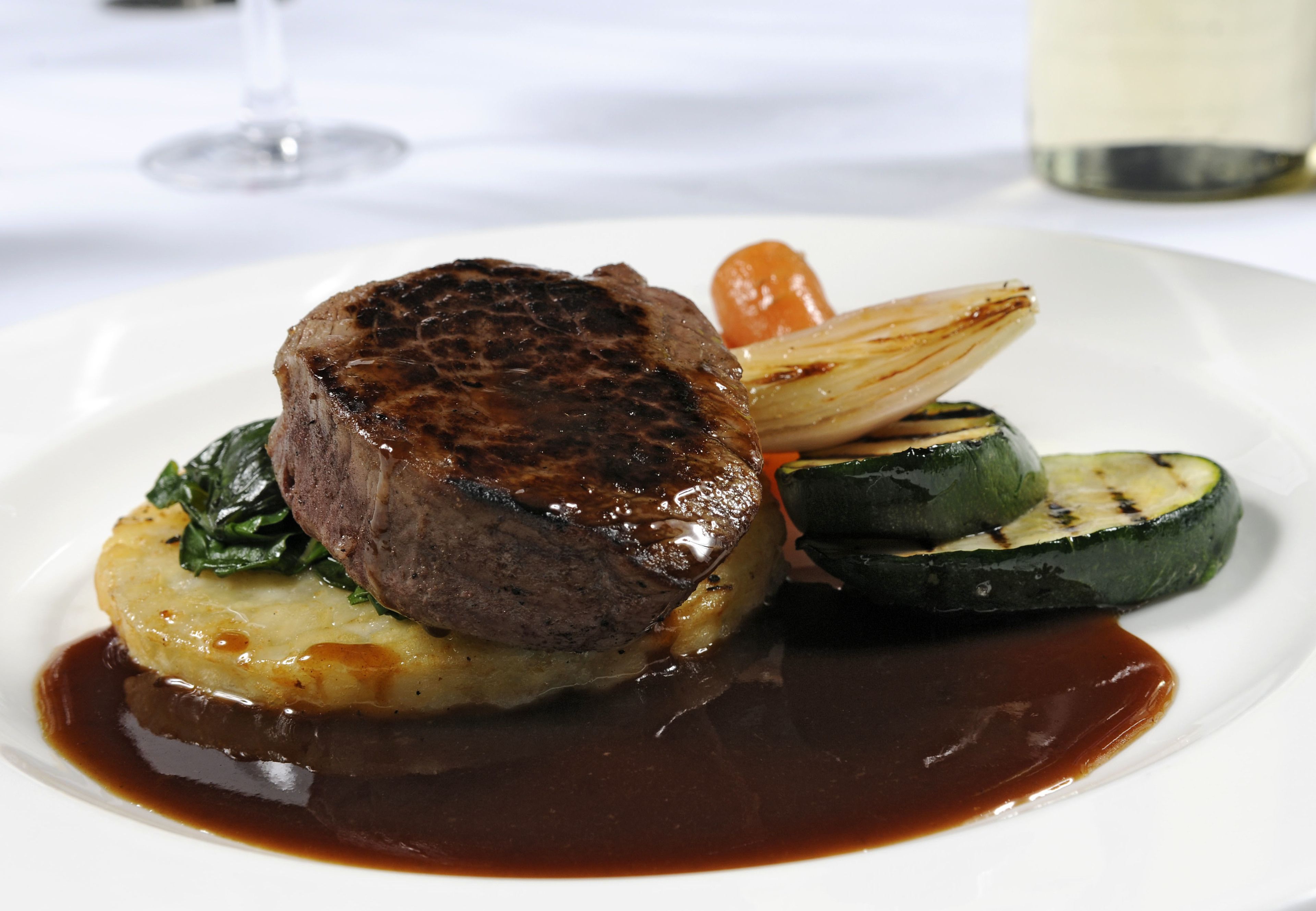 A plate of food with a steak, potatoes, and vegetables.