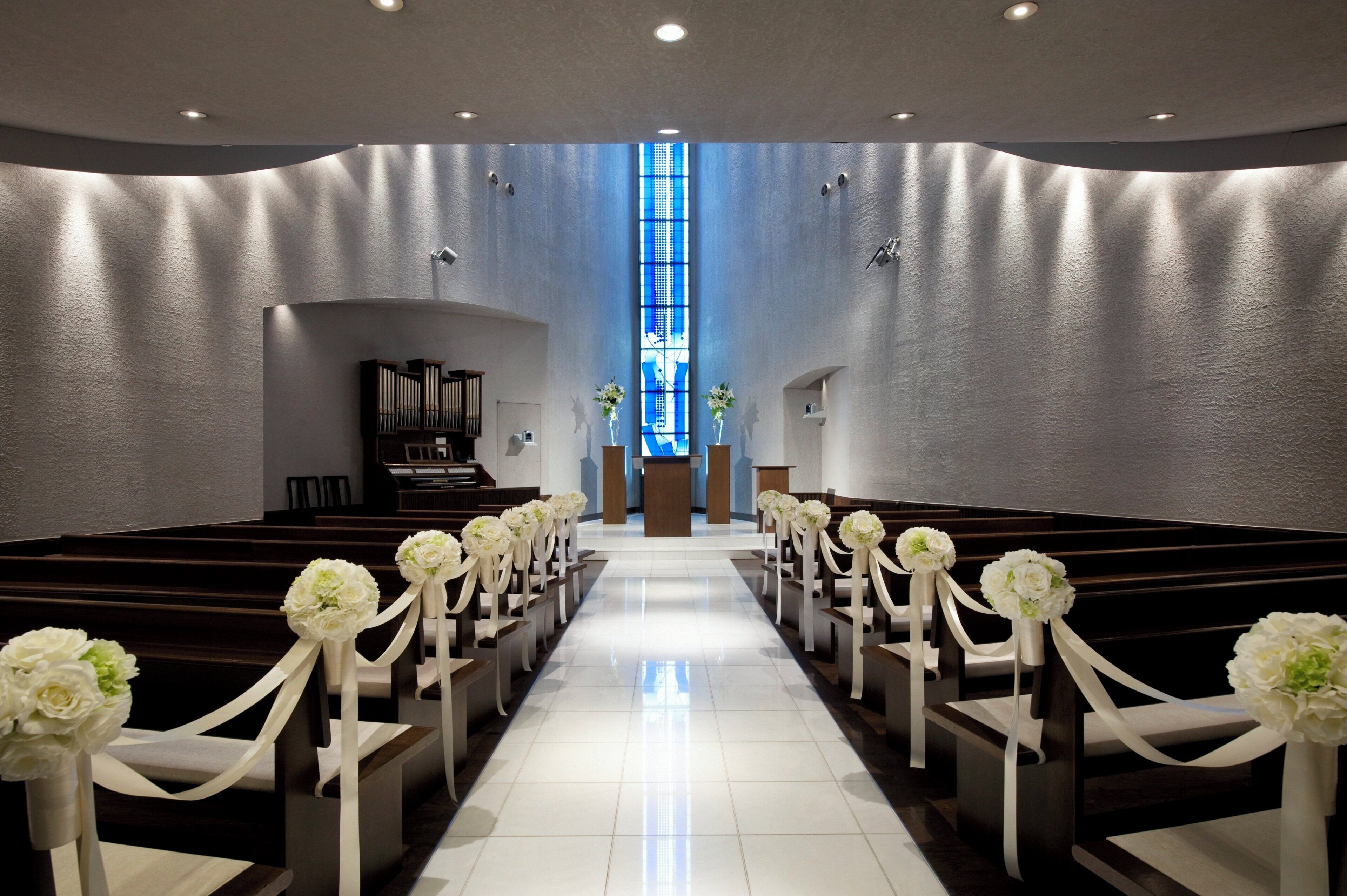 A church interior with pews, a piano, and a stained glass window.