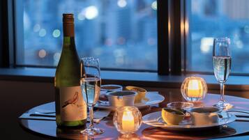 A table set for dining with a bottle of wine, glasses, and candles.