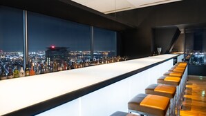 A bar with a city view, modern design, and a long counter with stools. - ANA Crowne Plaza Kobe by IHG (Kobe)