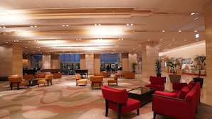 A spacious lobby with multiple seating areas, a reception desk, and a piano. - ANA Crowne Plaza Kobe by IHG (Kobe)