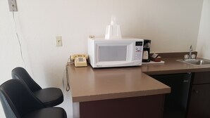 A kitchen with a microwave, a telephone, and a sink. - Americas Best Value Inn & Suites International Falls (International Falls)