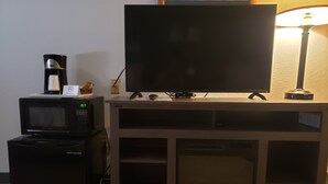 A kitchenette with a microwave, coffee maker, and a flat-screen TV on a stand. - Americas Best Value Inn & Suites International Falls (International Falls)