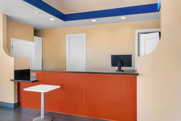 A reception area with a counter, a small table, and a television. - Americas Best Value Inn Vacaville Napa Valley (Vacaville)