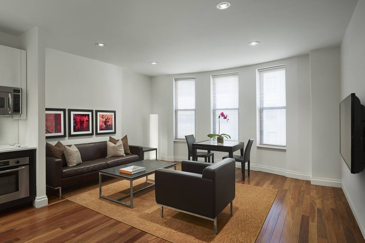 A modern living room with a sofa, coffee table, and dining area.
