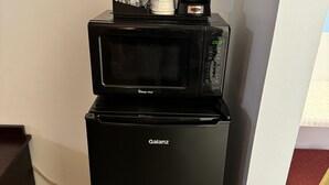 A black Galanz refrigerator with a microwave on top. - Inn Towne Motel (Herkimer)