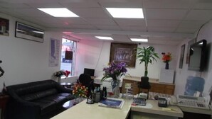 An office with a desk, computer, phone, and a black leather couch. - Inn Towne Motel (Herkimer)