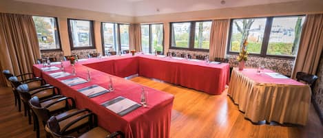 A conference room with a long table, chairs, and large windows.