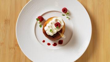Une assiette blanche avec un dessert posé sur une table en bois.