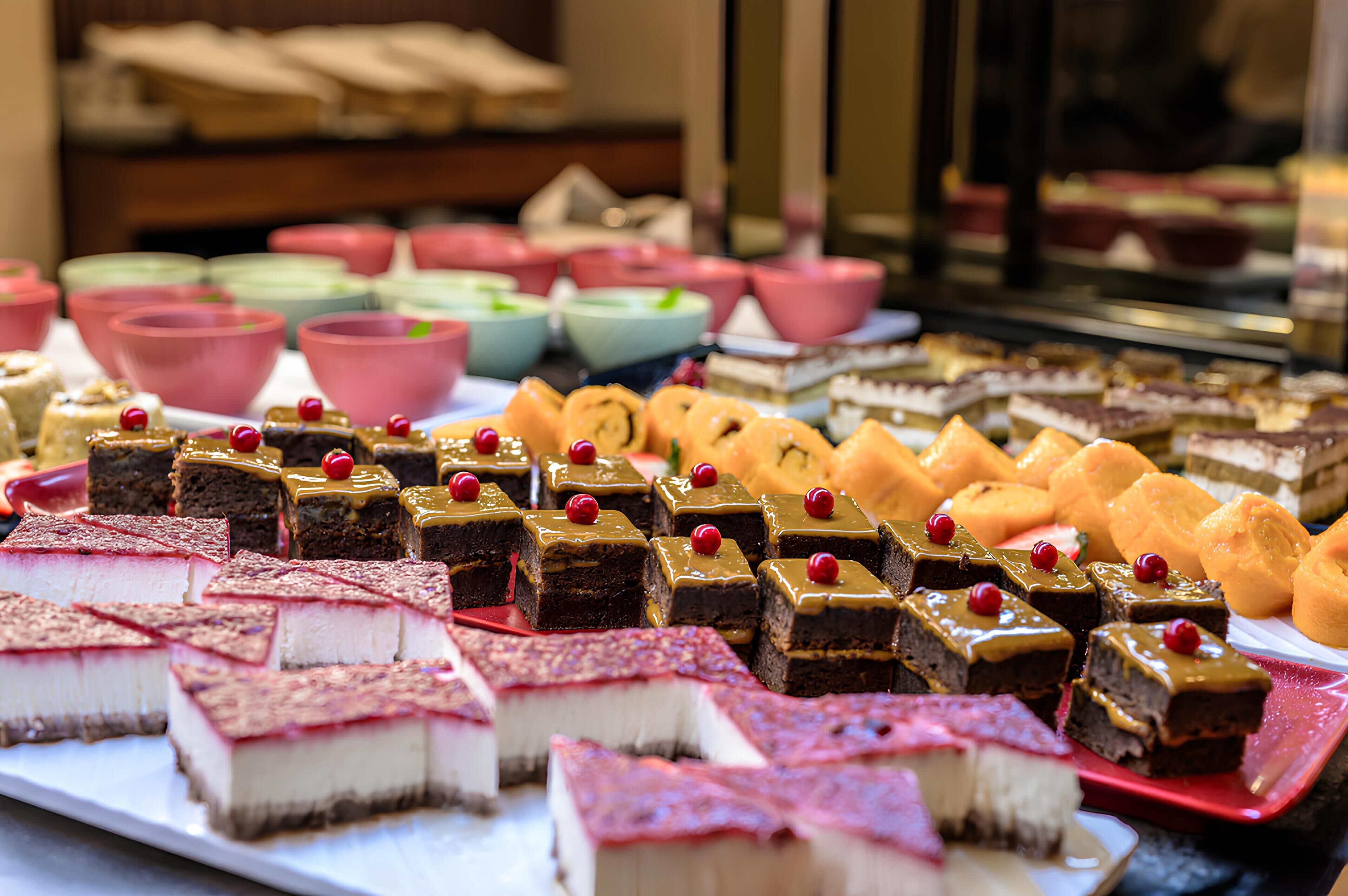 A variety of desserts on display, including brownies, cheesecakes, and other sweet treats.