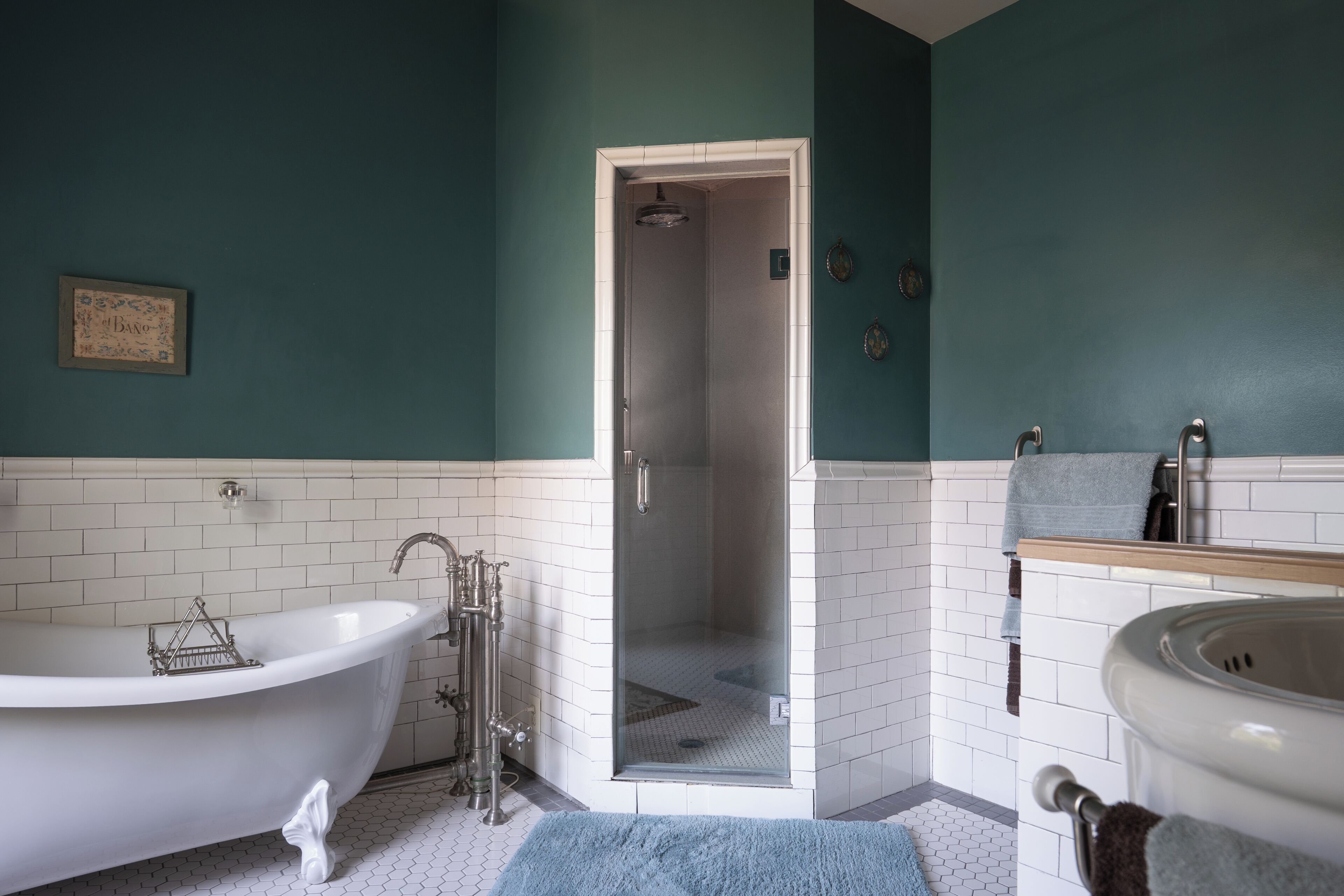 A bathroom with a freestanding bathtub, a shower enclosure, and a sink with a towel rack.