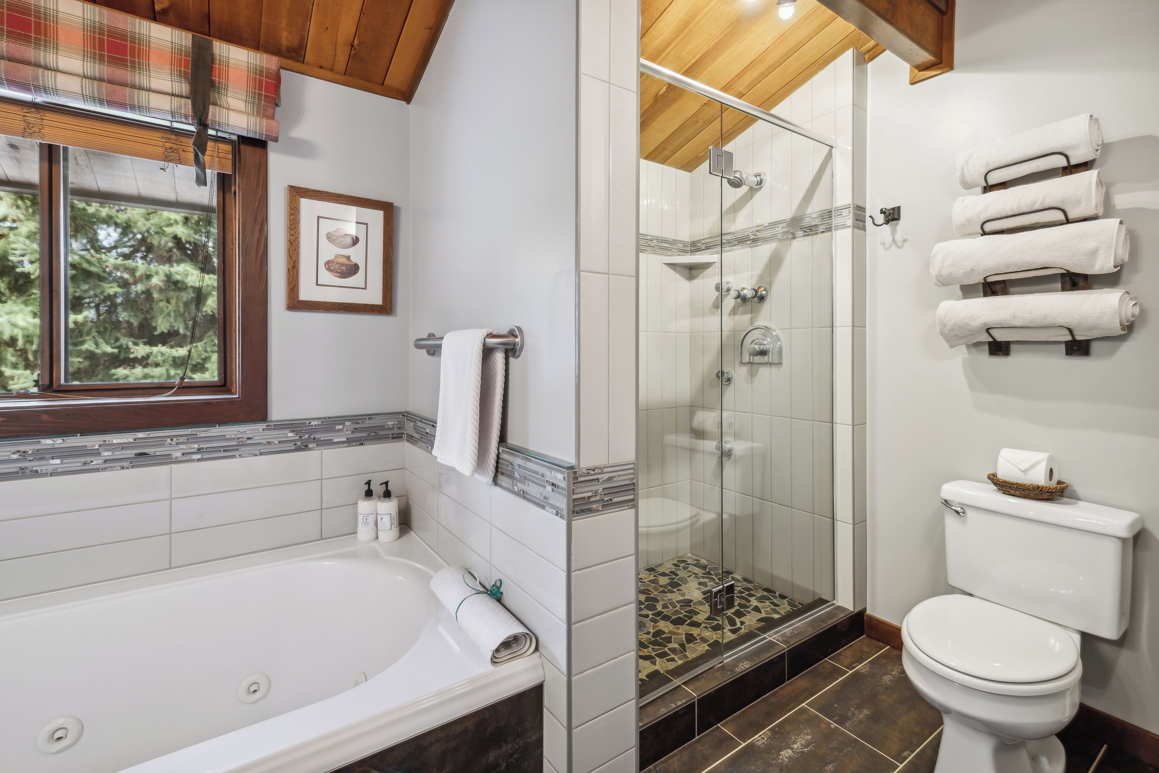 Une salle de bain équipée d’une baignoire, de toilettes et d’une douche à parois en verre.