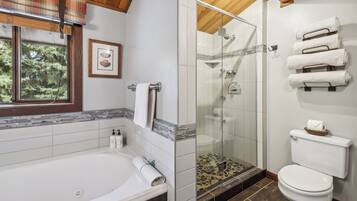 Une salle de bain équipée d’une baignoire, de toilettes et d’une douche à parois en verre.