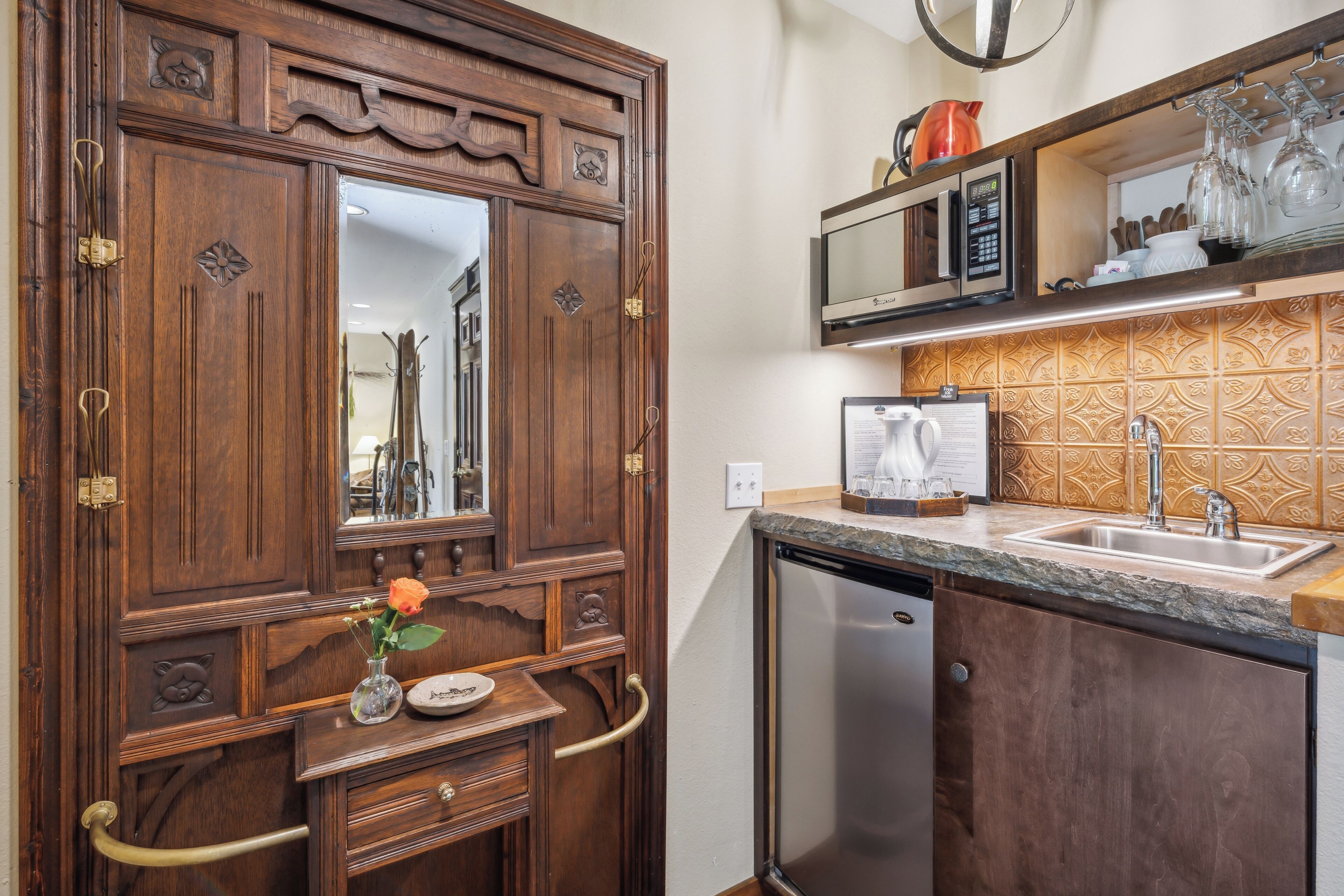 A kitchen with wooden cabinetry, a built-in microwave, and a stainless steel dishwasher.