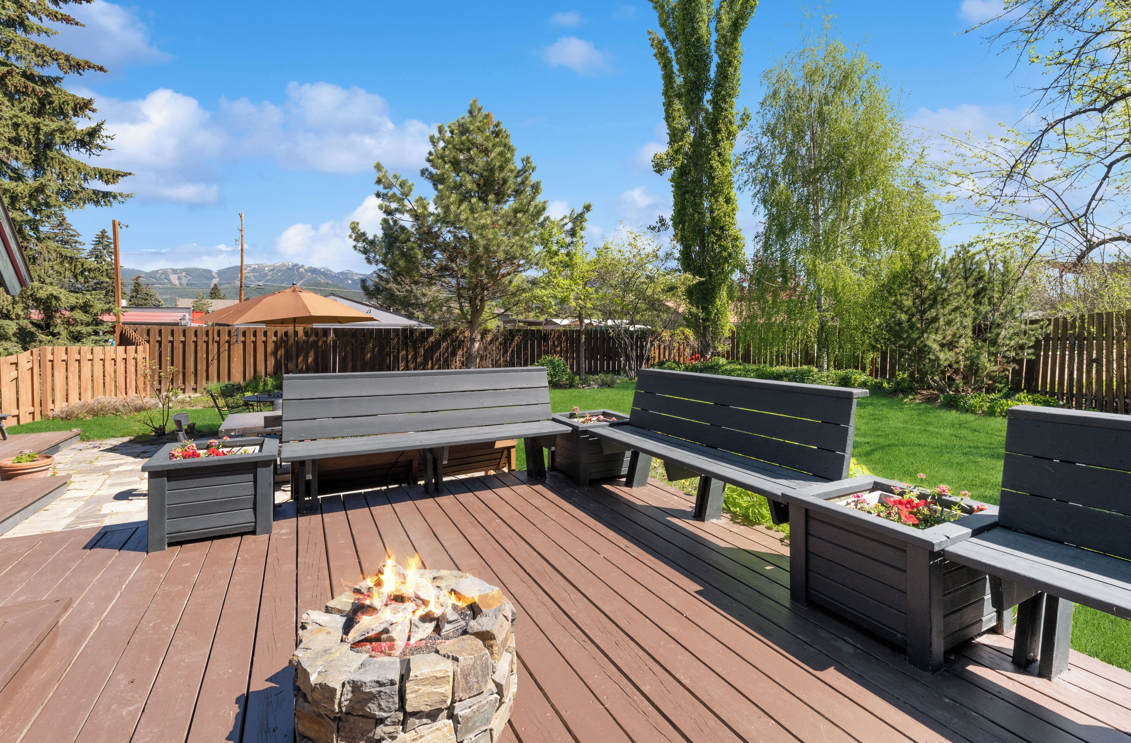 Une terrasse avec des sièges et un foyer extérieur.