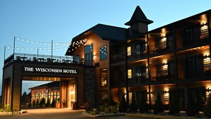 Ein mehrstöckiges Hotel mit einem markanten Eingang, auf dem "The Wisconsin Hotel" steht.