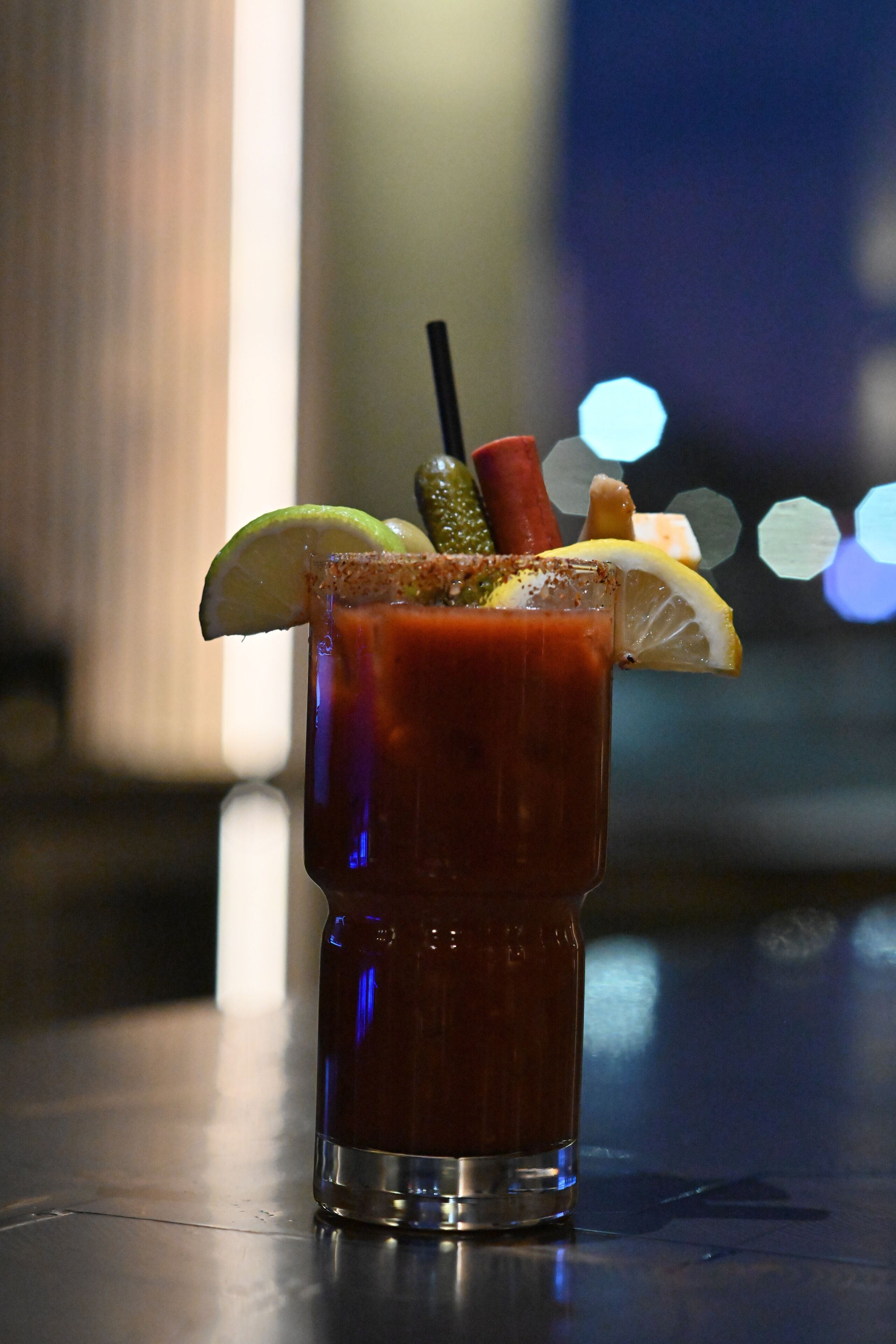 A Bloody Mary cocktail with garnishes, served in a tall glass.