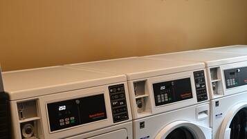 A laundry area with multiple washing machines and a sign above stating "WISCONSIN HOTEL WASH & DRY LAUNDRY SERVICE CO."