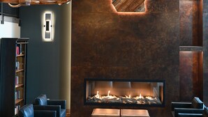 Eine moderne Lobby mit Kamin, Ledersitzgelegenheiten und einem einzigartigen Wanddesign.