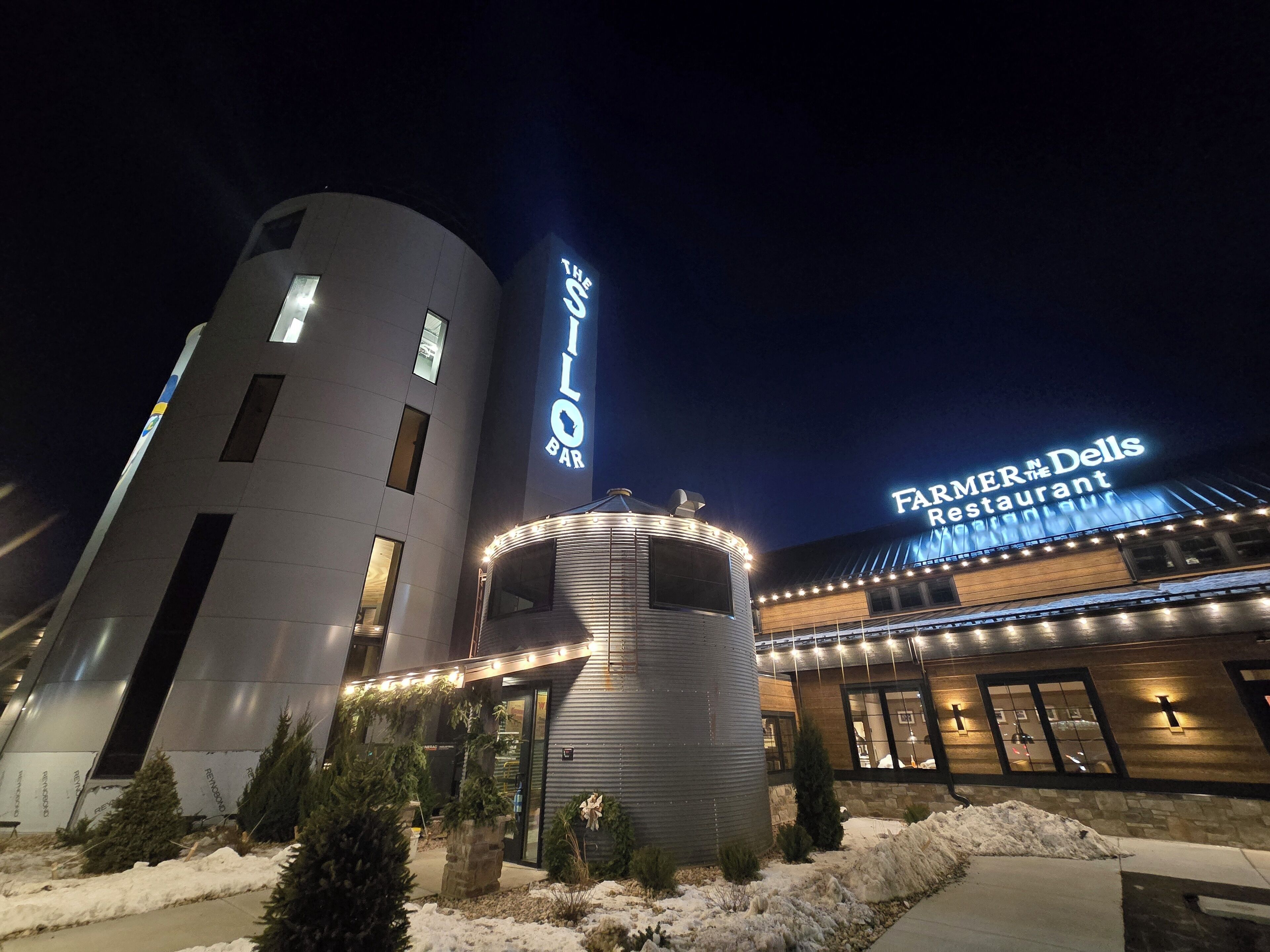 A modern building with a bar named "The Silo Bar" and a restaurant called "Farmer & Dells Restaurant."