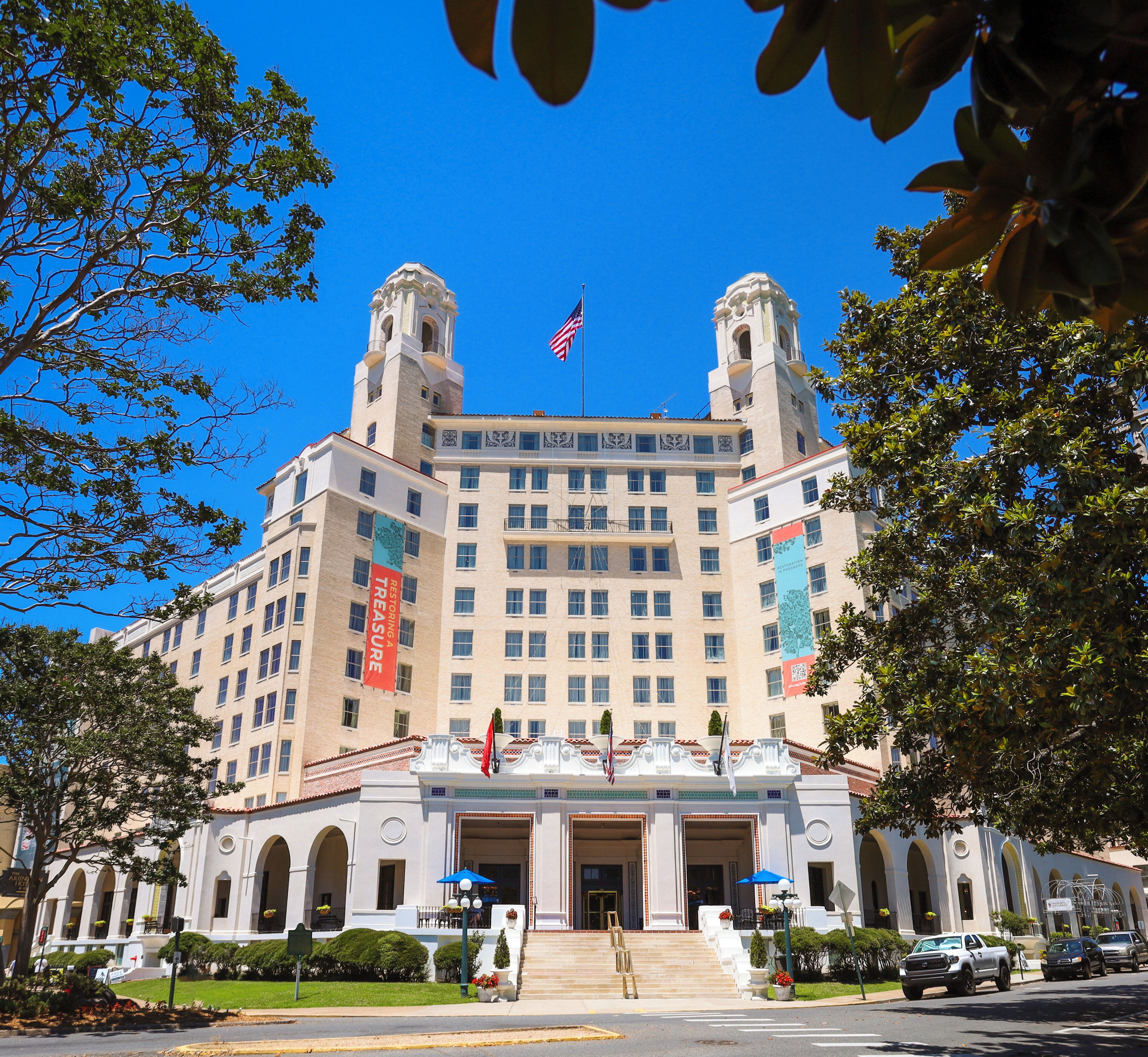 A large, historic building with a central entrance, two towers, and an American flag.