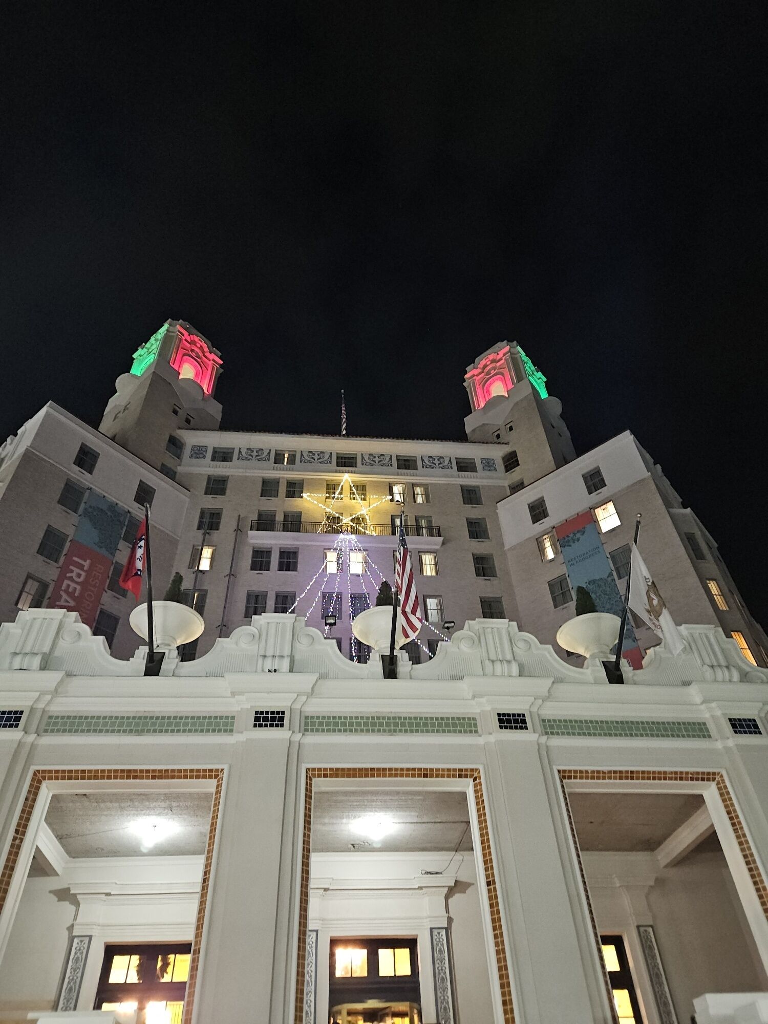 A large building with a central tower, multiple flags, and a star-shaped light decoration.
