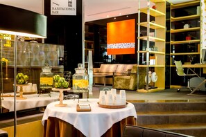 A hotel lobby with a reception desk, seating area, and a bar. - Hotel Eurostars Monte Real (Madrid)