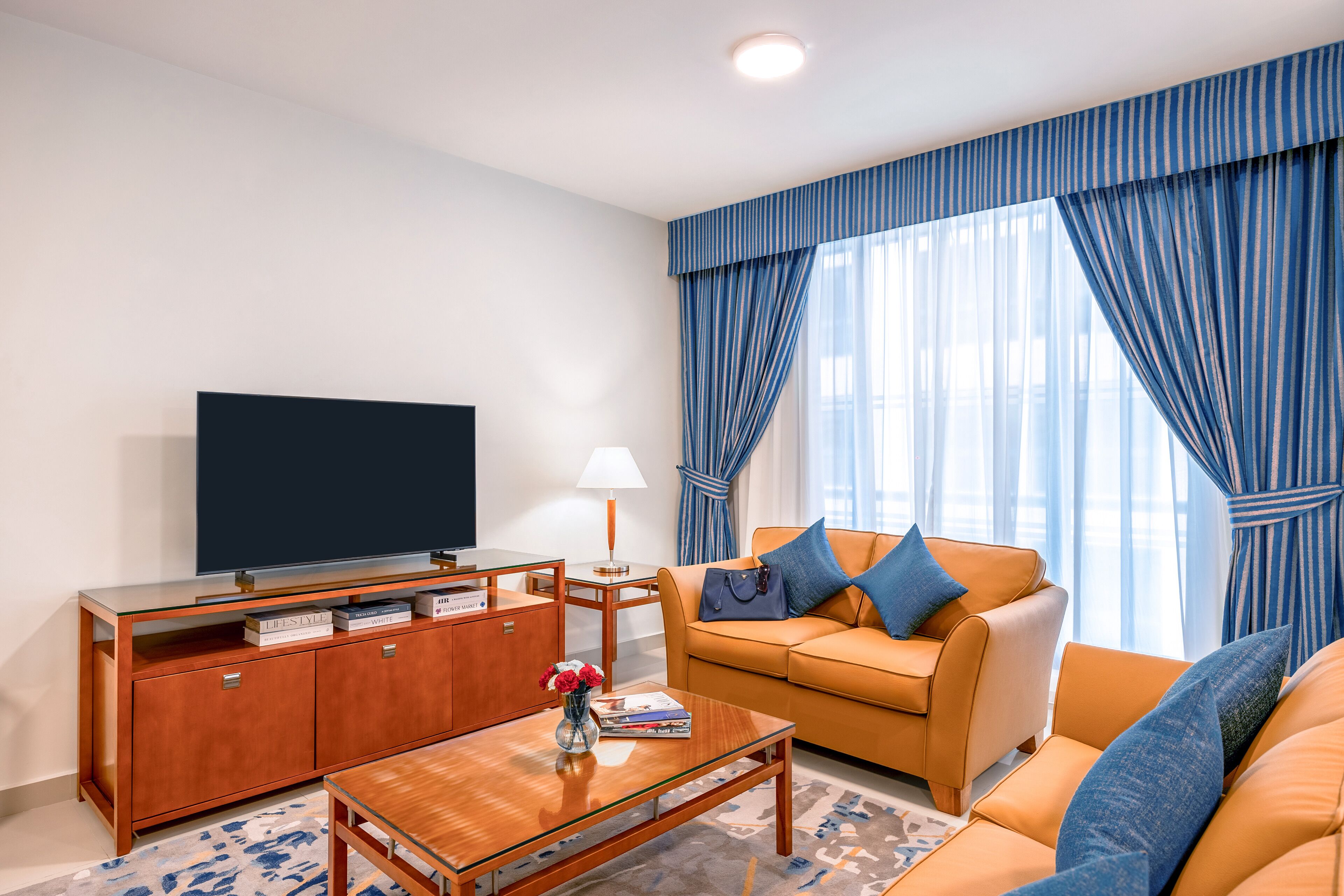 Ein modernes Wohnzimmer mit Sofa, Couchtisch, Fernseher und Schrank.