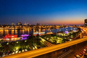 A nighttime cityscape with a river, illuminated buildings, and a bridge. - Riviera Hotel Dubai (Dubai)