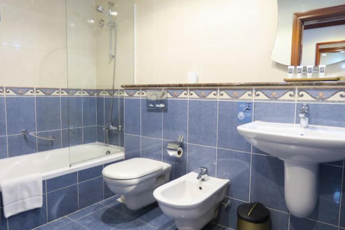 A bathroom with a bathtub, toilet, bidet, and sink.