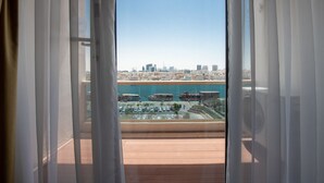 A view from a balcony with sheer curtains, overlooking a marina with boats and a city skyline in the background. - Riviera Hotel Dubai (Dubai)