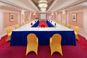 Una sala de conferències amb una taula llarga, cadires grogues i una catifa vermella.