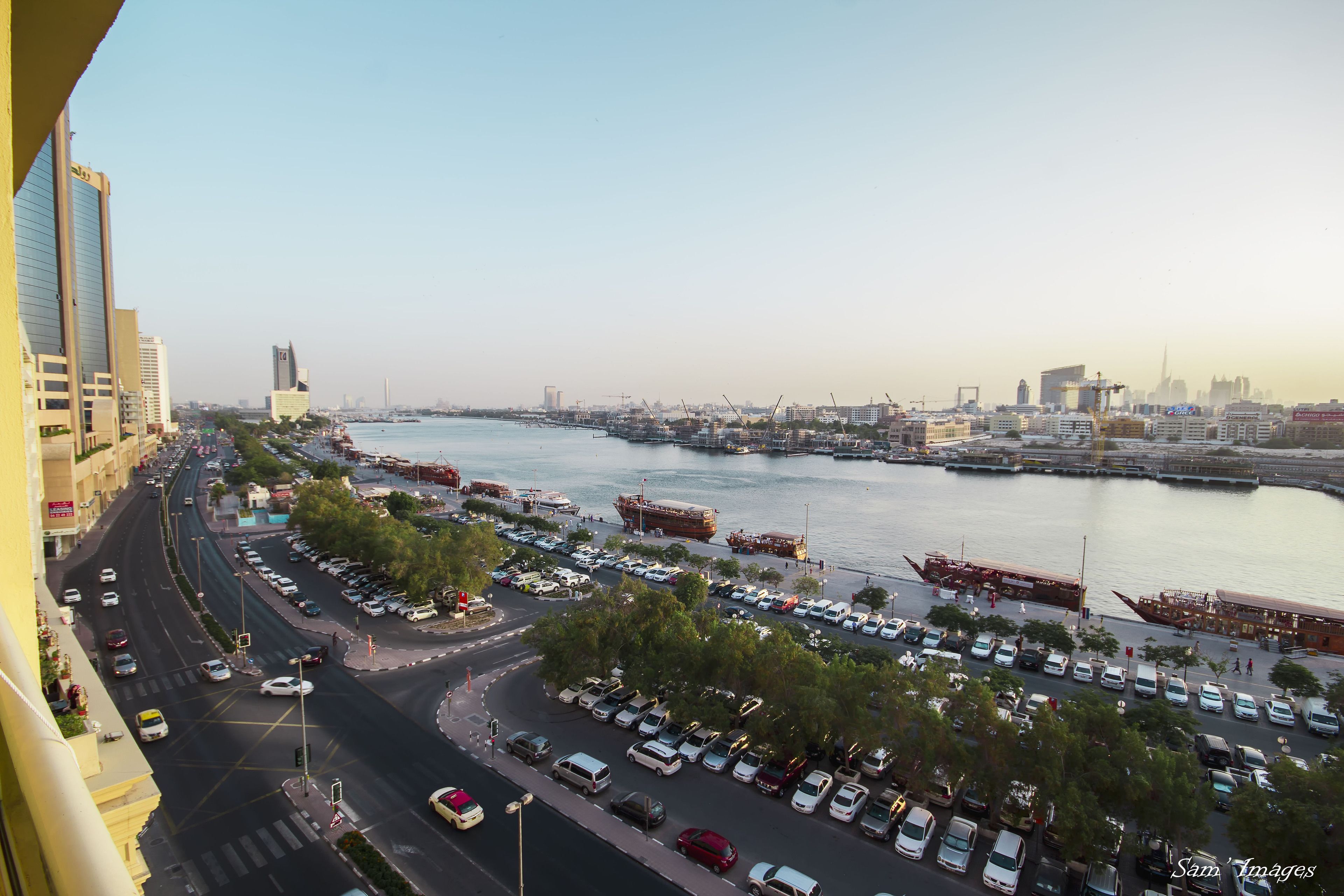 A cityscape with a river, boats, and a busy waterfront area.