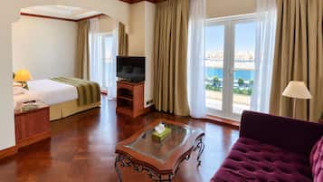 Ein Hotelzimmer mit Bett, Fernseher, Sofa und Blick auf die Stadt.
