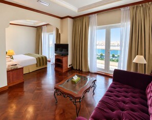 A hotel room with a bed, a television, a sofa, and a view of the city. - Riviera Hotel Dubai (Dubai)